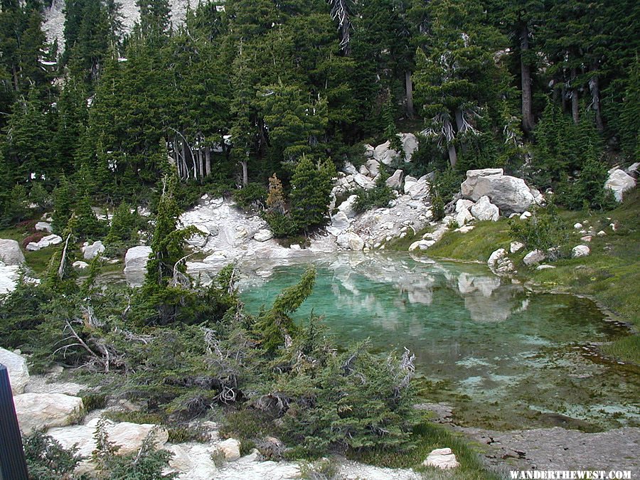 A turquoise green shallow cool water pool above the Bumpass Hell hydrothermal area