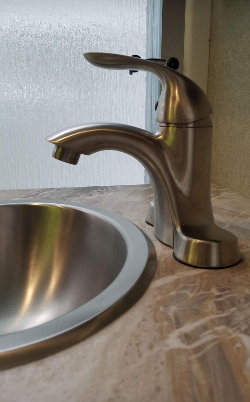 Replaced OEM bathroom sink faucet with a longer reach single lever faucet.